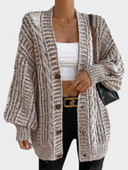Woman posing in a cream oversized chunky knit cardigan, highlighting the open front and balloon sleeves.