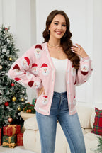 Woman wearing a pink Santa Claus print knit cardigan with a V-neck and button-down front.