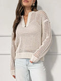 Woman in a cream open-knit sweater with a half-zip neckline, paired with light wash jeans.