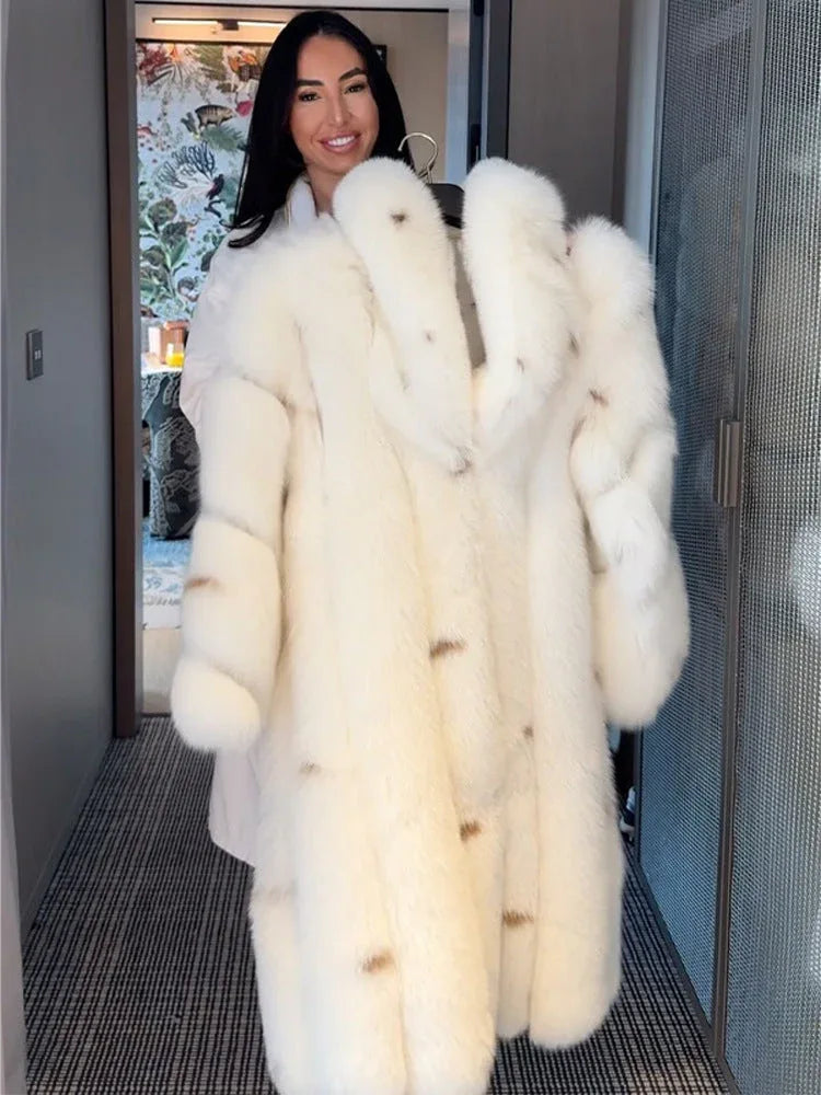 Woman holding a white faux fur coat on a hanger.
