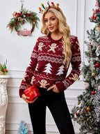 Woman holding a red gift box while wearing a festive knit sweater.