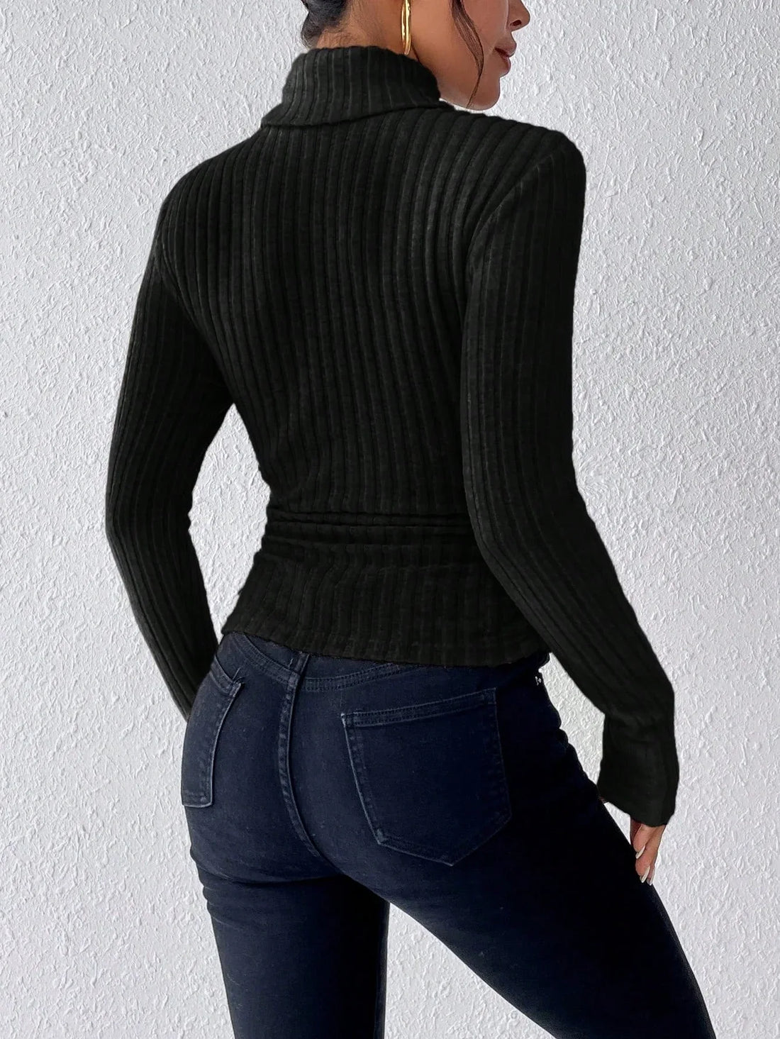Woman wearing a black ribbed turtleneck top