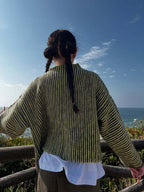 Woman posing in a relaxed fit chevron knit cardigan by the ocean