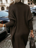 Rear view of a woman wearing a long brown ribbed knit cardigan, showcasing the back and sleeve details.