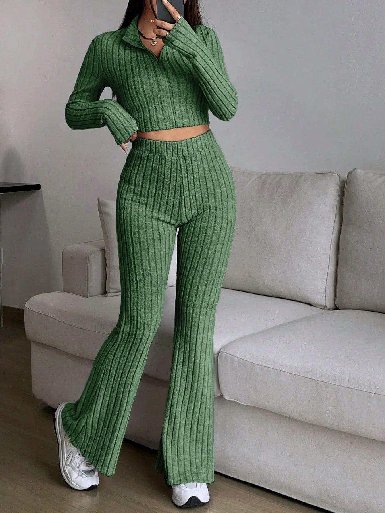 Woman wearing a green ribbed knit cropped top and flared pants set