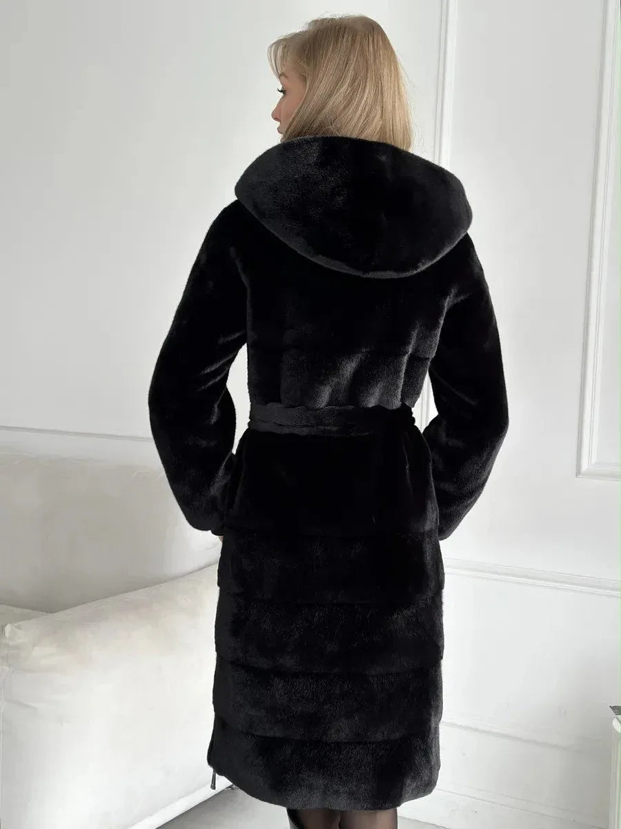 Back view of a woman in a black faux fur coat with a hood and belted waist.