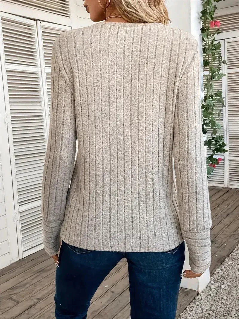 Woman wearing a beige ribbed knit crew neck long sleeve top