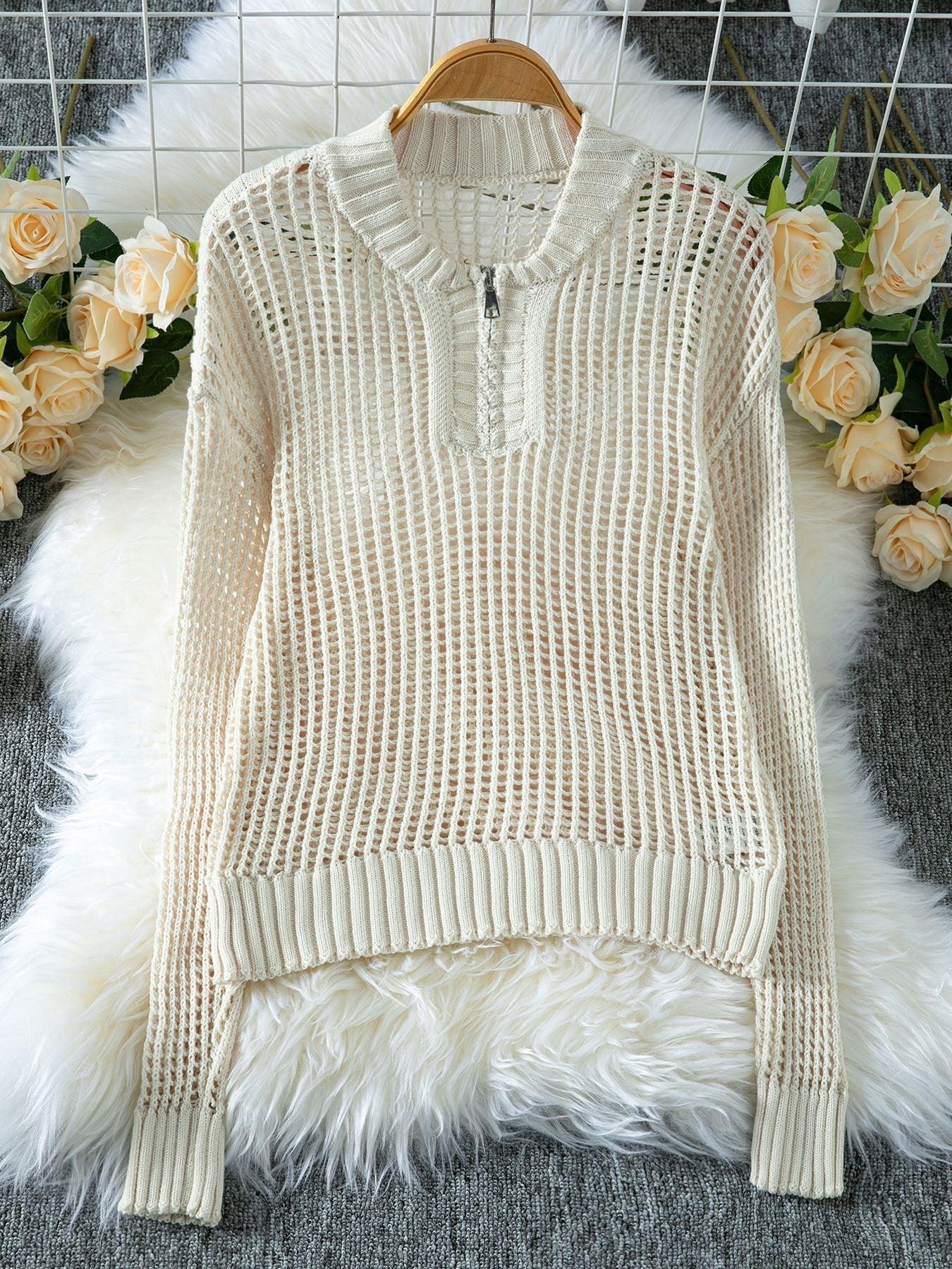 Cream open knit sweater with a quarter-zip closure displayed on a hanger