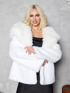 Woman wearing a white faux fur coat with a wide collar.