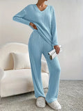 woman in a light blue ribbed knit lounge set holding a silver clutch