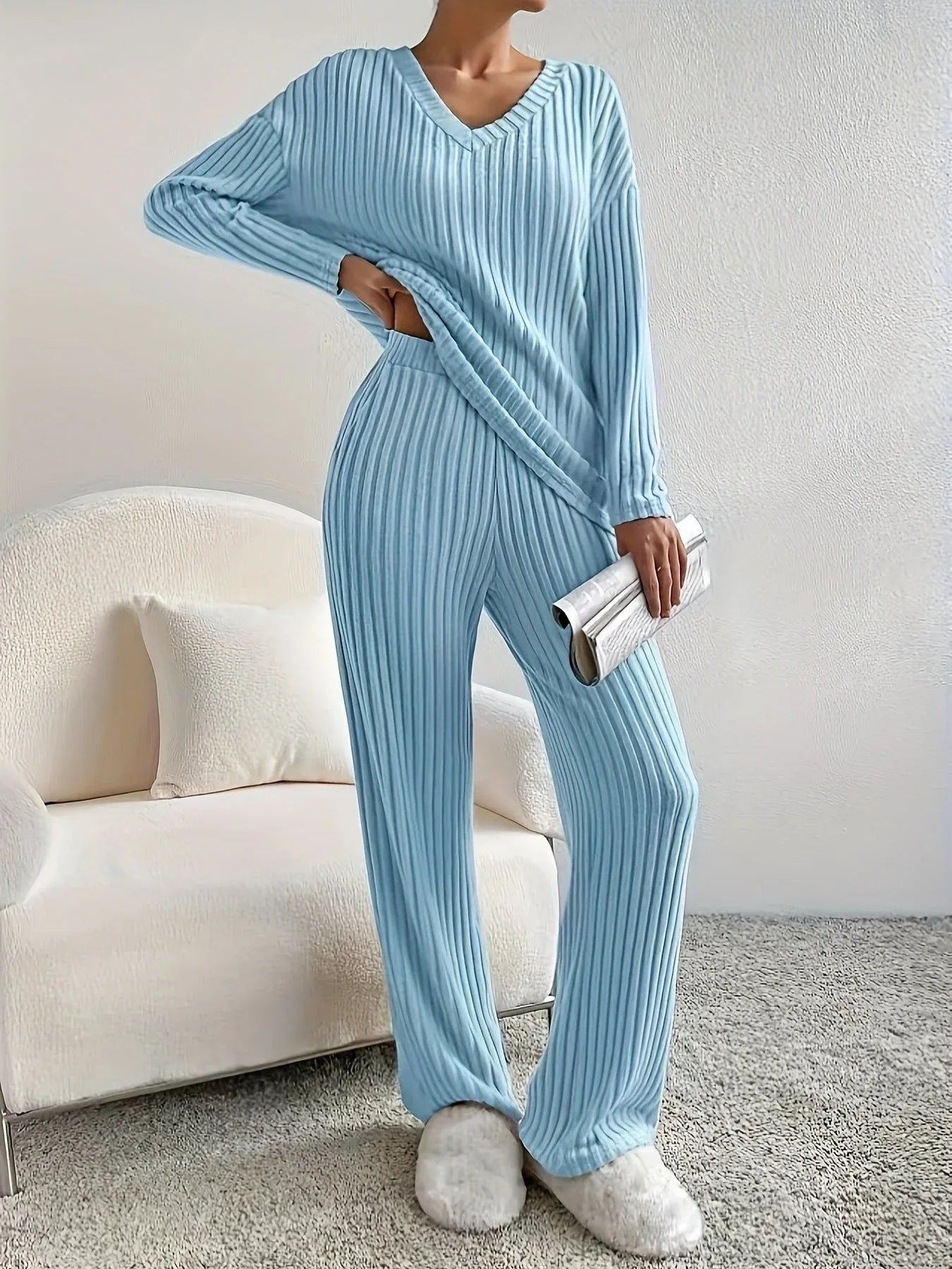 woman in a light blue ribbed knit lounge set holding a silver clutch