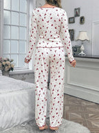 Back view of woman in white pajamas with red floral print and scalloped trim.