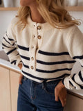 Woman with hands on hips wearing a striped knit sweater.