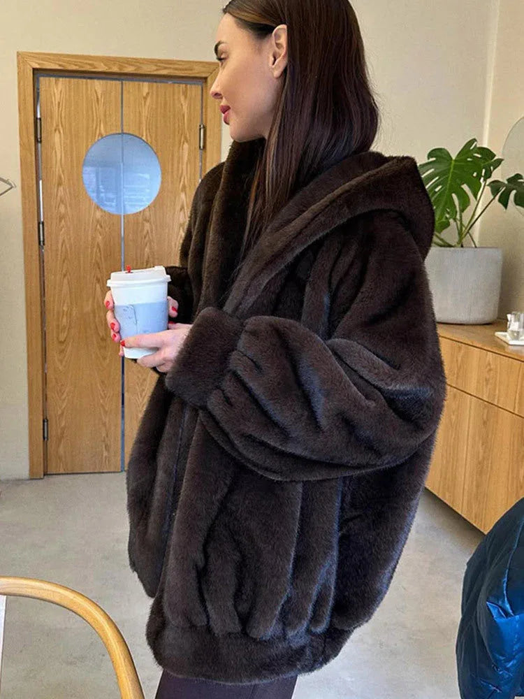 Close-up of a woman wearing a brown faux fur hooded jacket.