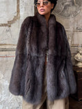 Front view of a woman wearing a plush dark brown fur coat with a prominent collar.