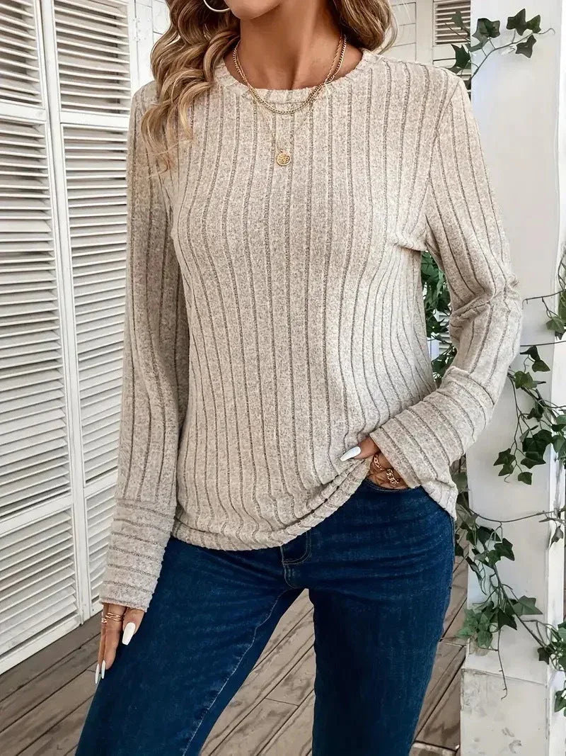 Woman wearing a beige ribbed knit crew neck long sleeve top