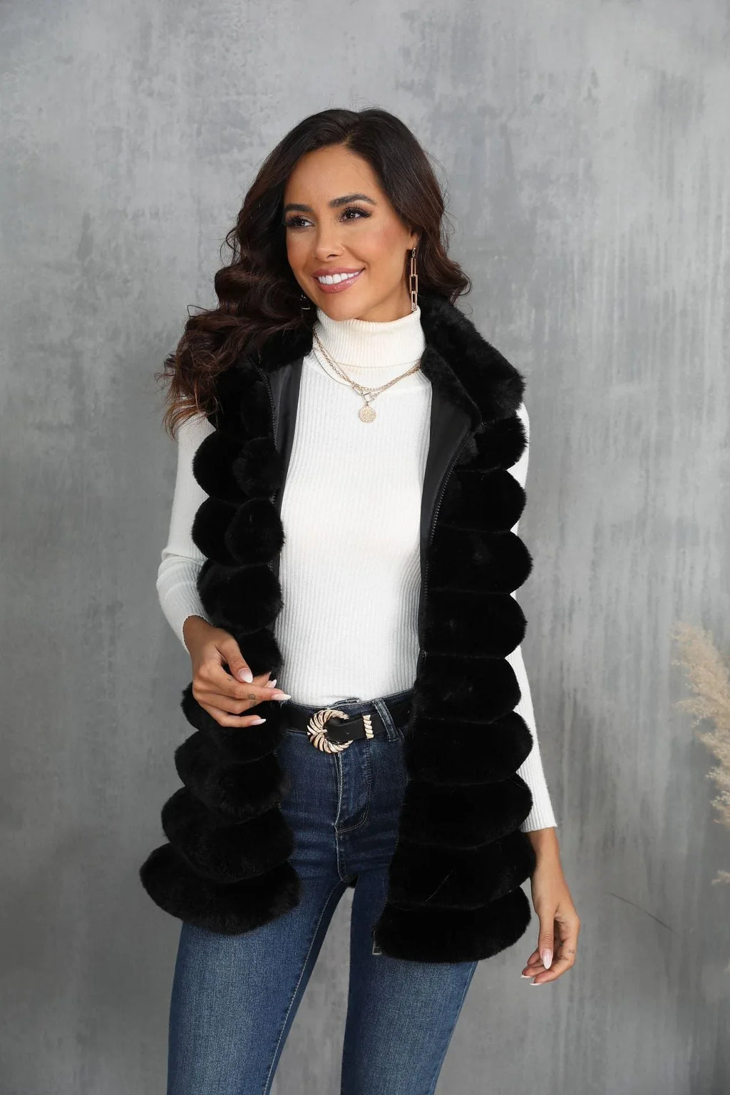 Front view of a woman wearing a black faux fur vest and gold jewelry