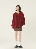 Fashionable woman posing in a red cable knit hooded cardigan