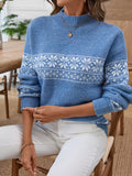 Close-up of a woman's arm in a blue Nordic snowflake mock neck sweater