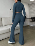 Back view of a woman in a blue ribbed knit set with a cropped top and flared pants
