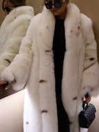 Woman in a white faux fur coat and black outfit, reflected in a mirror.