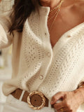 Detail of cream knit cardigan with button front and open knit pattern
