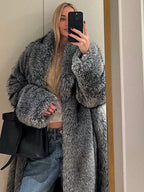 Woman taking a mirror selfie wearing a long grey faux fur coat with lapel collar and full length sleeves.