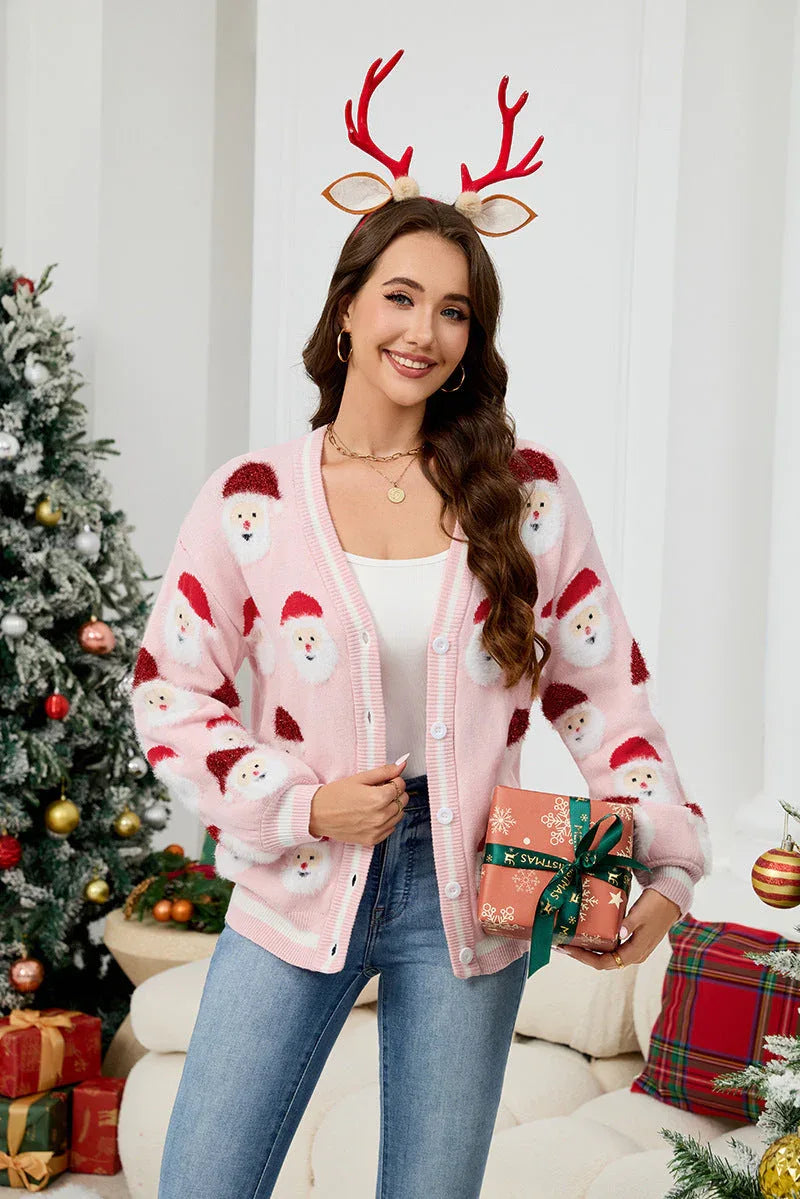 Close-up of a woman's hands holding a gift box while wearing a pink Santa Claus print cardigan.