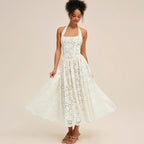 Woman wearing a white lace halter midi dress, twirling to show skirt
