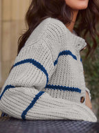 Close-up of the knit texture and striped pattern on a gray cardigan.