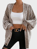Back view of a woman in a cream oversized chunky knit cardigan with ribbed texture.