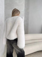Rear view of a woman in a white faux fur cropped jacket.