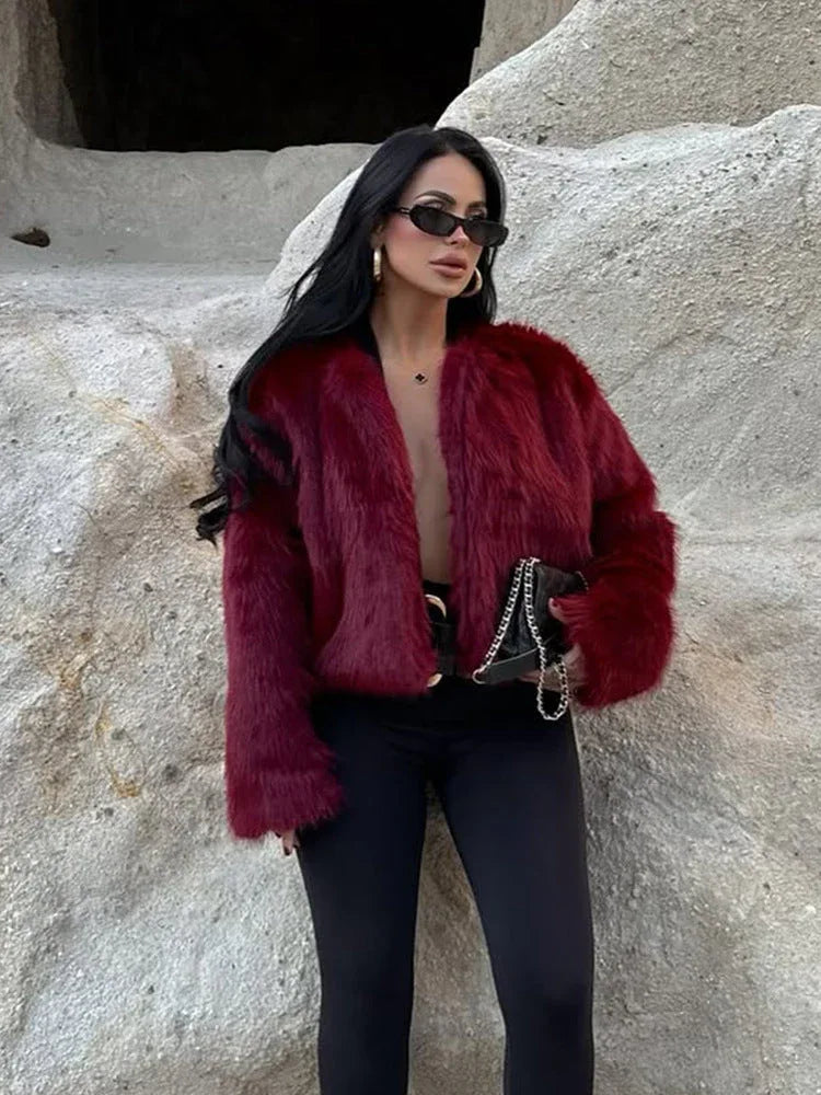 Woman wearing a burgundy faux fur cropped jacket with an open front and long sleeves. Main image