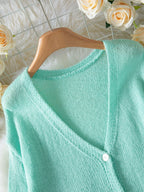 Close-up of the V-neckline on a mint green cardigan