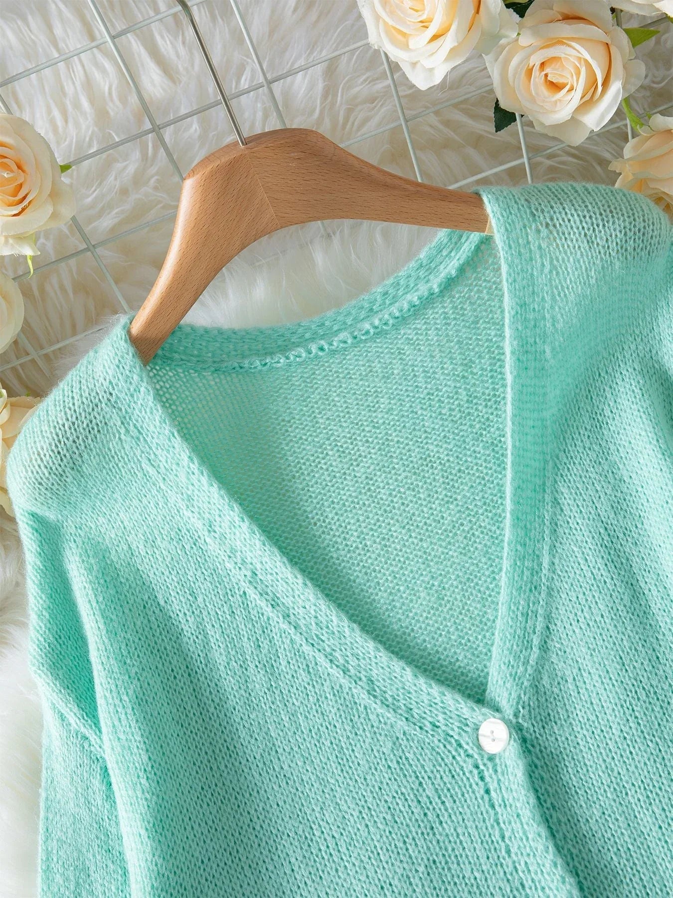 Close-up of the V-neckline on a mint green cardigan