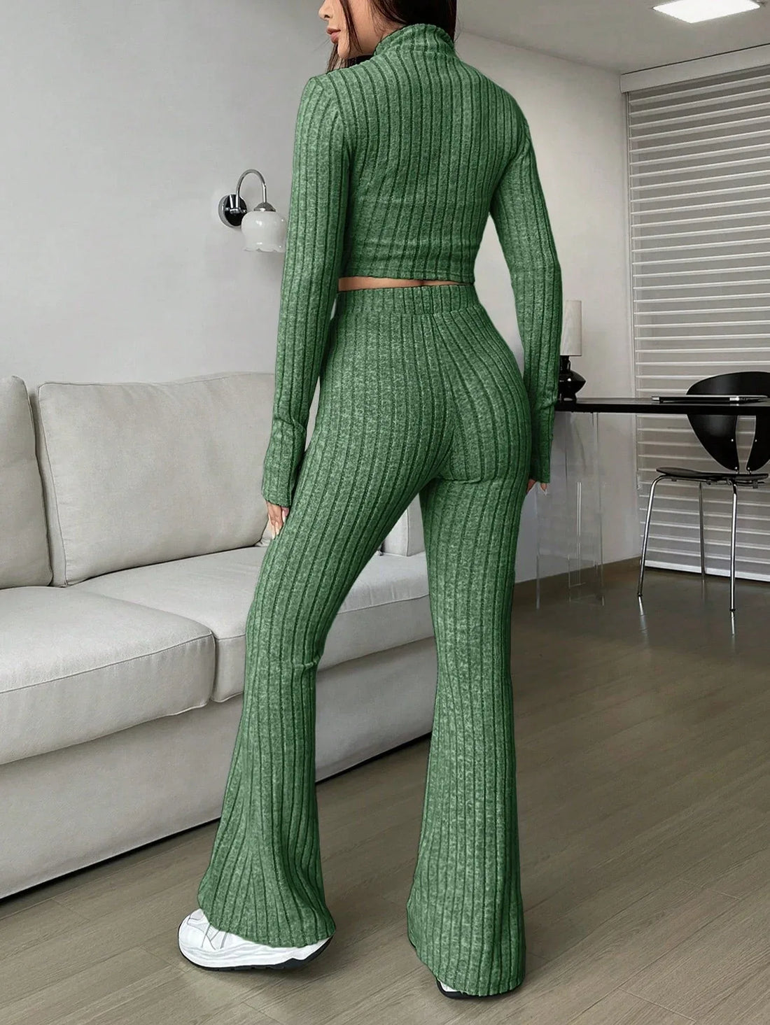 Woman wearing a green ribbed knit cropped top and flared pants set
