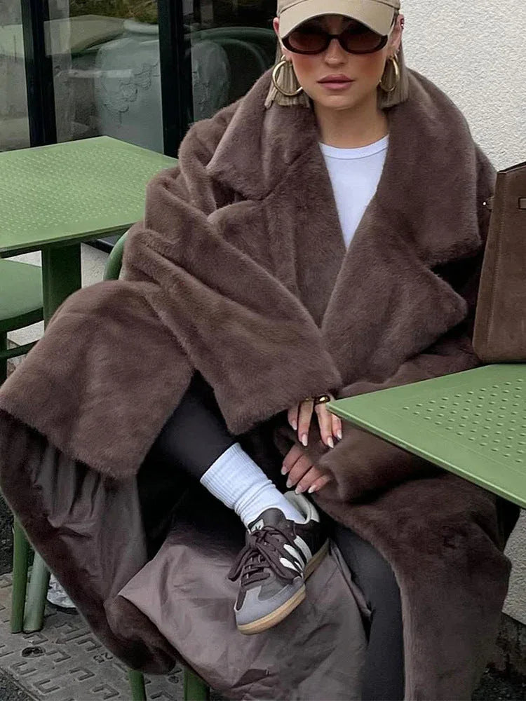 Woman in a brown faux fur coat with a white t-shirt and black leggings.