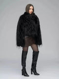 Rear view of a woman in a black shaggy faux fur jacket and brown faux leather wrap dress