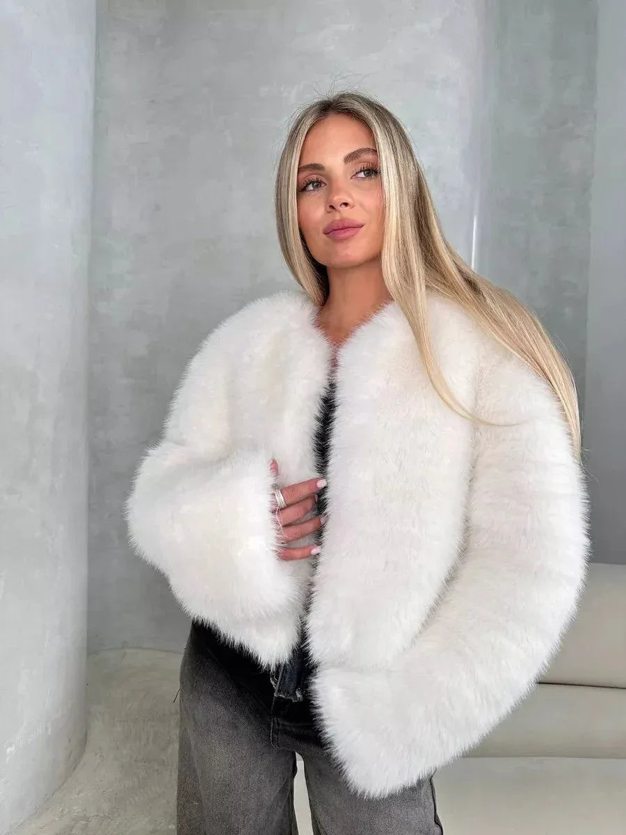Woman wearing a white faux fur cropped jacket with an open front and long sleeves. Main image