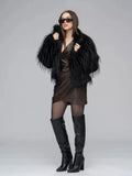 Woman wearing a black shaggy faux fur jacket with a brown faux leather wrap dress and black boots