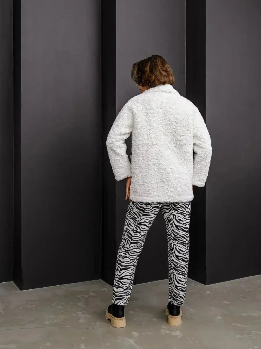 Back view of a woman in a white textured faux fur jacket