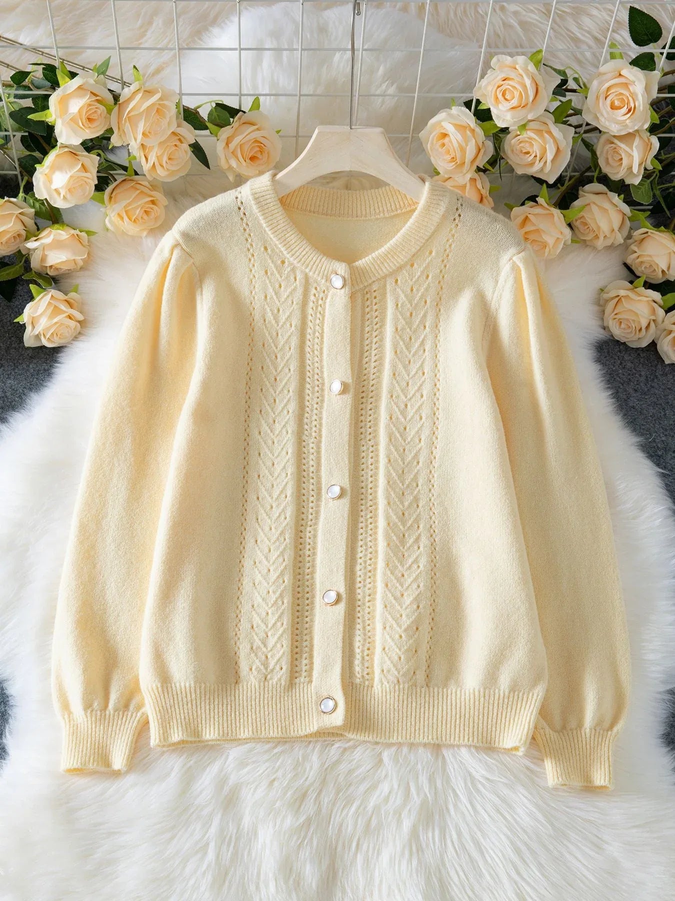 Light yellow knit cardigan with puff sleeves and button front laid flat