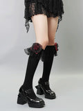 Black knee-high socks with ruffled lace trim and red rose embellishments on the calf.