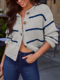 Woman showing the open button-up detail of a gray and navy striped knit cardigan.