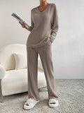 woman wearing a taupe ribbed knit lounge set holding a magazine