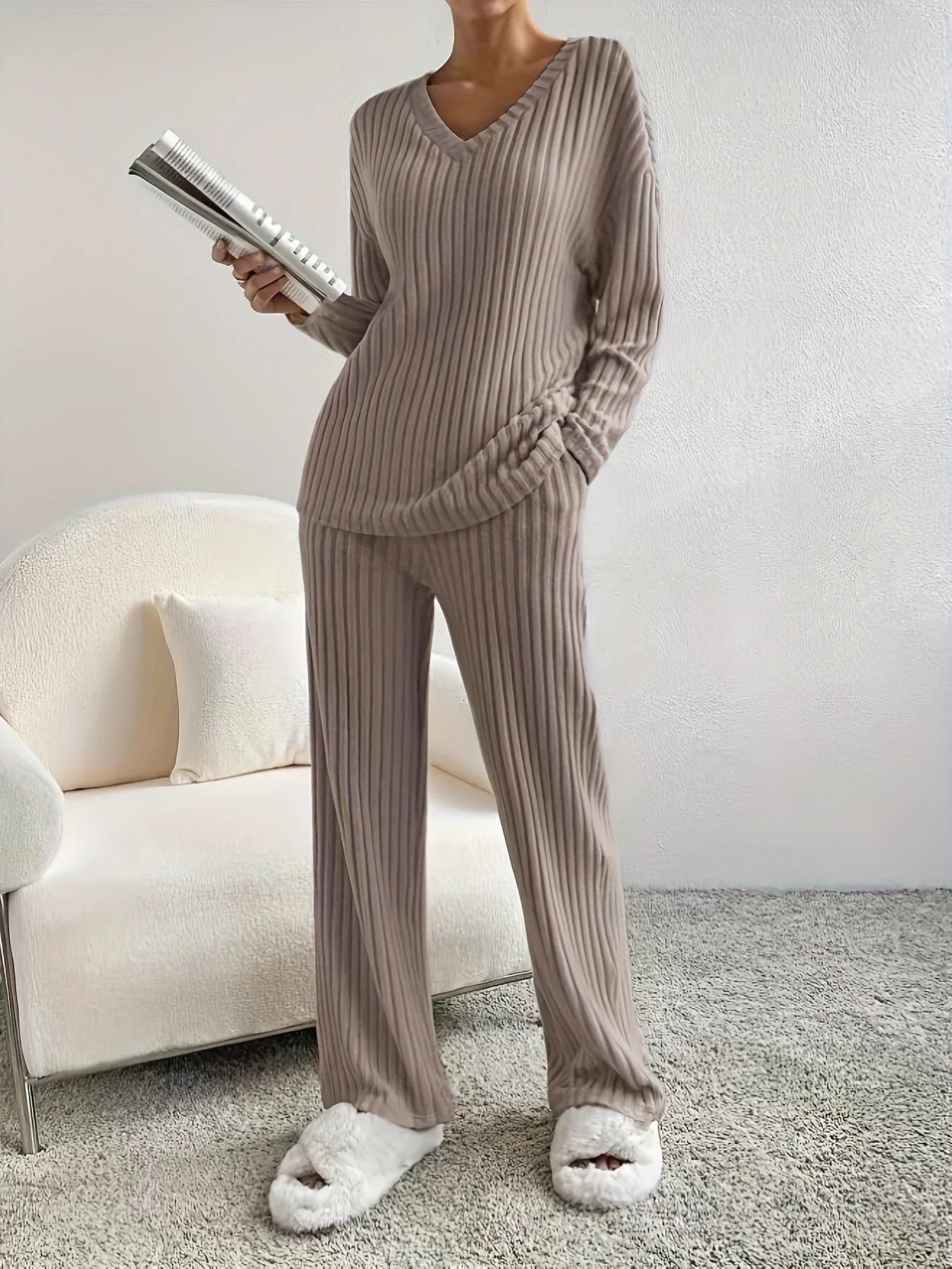 woman wearing a taupe ribbed knit lounge set holding a magazine