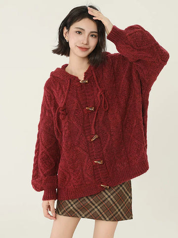 Woman wearing a red hooded cable knit cardigan with toggle buttons and a plaid skirt