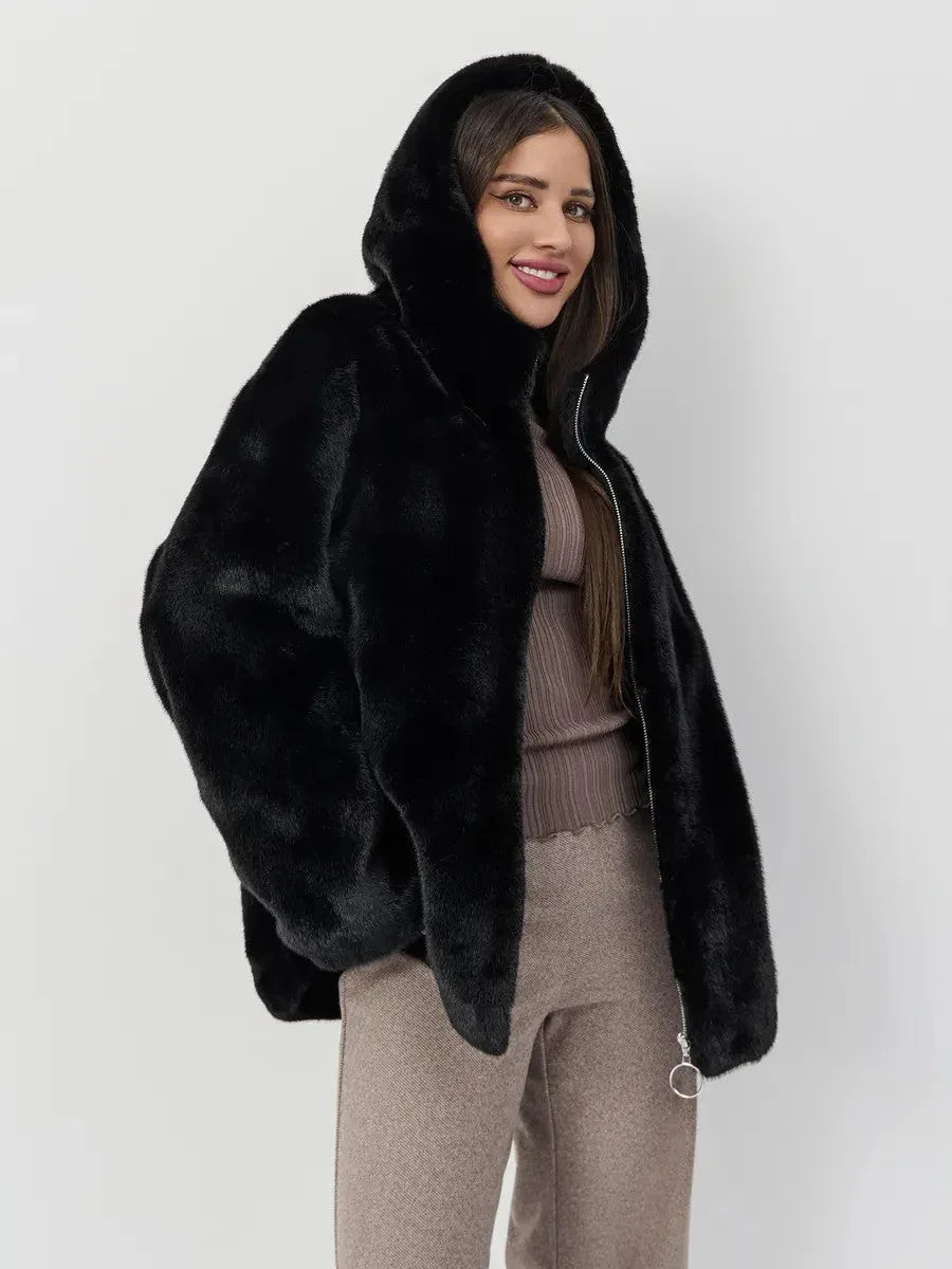 Woman wearing a black hooded faux fur jacket with a zipper closure and a taupe ribbed knit top. Main image