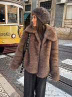 A stylish woman is pictured wearing a warm, textured brown faux fur jacket.