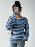 Woman in a blue and white striped knit sweater, holding a phone to her face